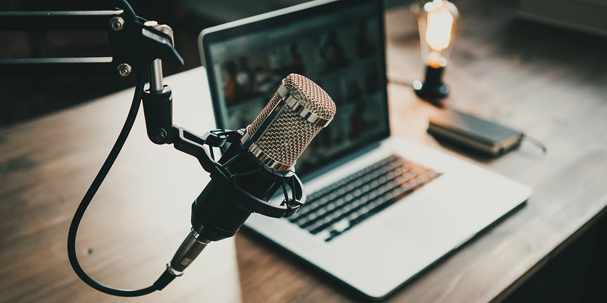 Photograph of a microphone and computer recording a podcast